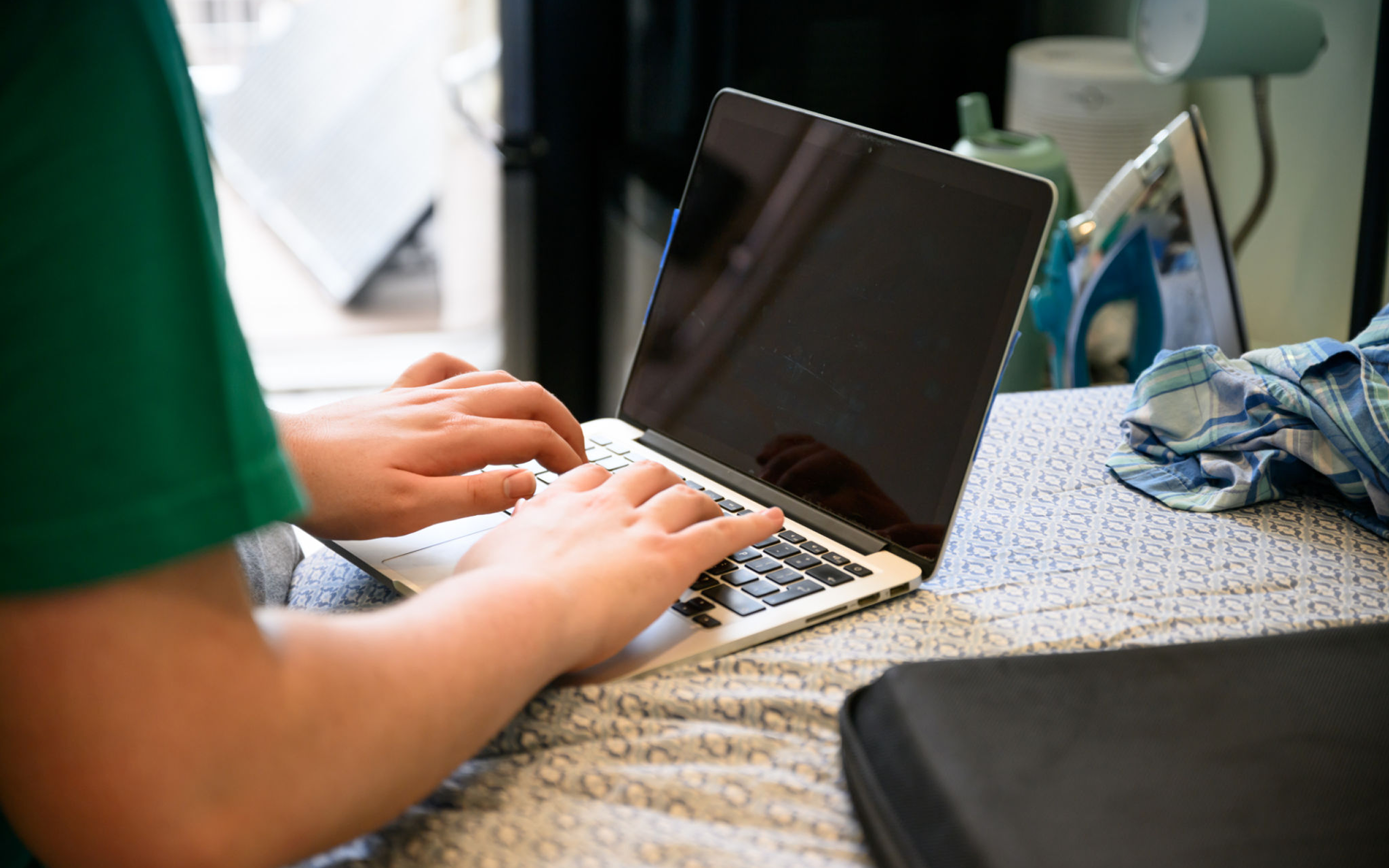 Typing on bed with laptop